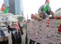 SENIMAN Pantomim Bandung, Wanggie bersama Mujahidah Sahabat Palestina menggelar aksi Solidaritas Bebaskan Palestina di Monumen Solidaritas Asia-Afrika, Jln. Asia Afrika, Kota Bandung, Senin (9/6/2025). (Eci/pasjabar)
