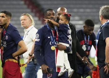 Pemain PSG Ousmane Dembele bersama anaknya di lapangan setelah laga final Liga Champions antara PSG dan Inter Milan di Allianz Arena di Munich, Jerman, Minggu, 1 Juni 2025. (c) AP Photo/Luca Bruno
