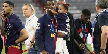 Pemain PSG Ousmane Dembele bersama anaknya di lapangan setelah laga final Liga Champions antara PSG dan Inter Milan di Allianz Arena di Munich, Jerman, Minggu, 1 Juni 2025. (c) AP Photo/Luca Bruno