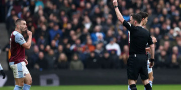 Wasit Chris Kavanagh memberi kartu merah langsung kepada kapten tim Aston Villa, John McGinn akibat pelanggaran keras terhadap bek Tottenham Hotspur, Destiny Udogie pada laga pekan ke-28 Premier League 2023/2024 di Villa Park, Birmingham, Minggu (10/3/2024). (AFP/Darren Staples)