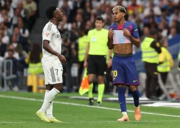 Vinicius Junior (kiri) berbicara dengan Lamine Yamal dalam pertandingan Liga Spanyol antara Real Madrid vs Barcelona di Stadion Santiago Bernabeu di Madrid pada 26 Oktober 2025. (Foto oleh Oscar DEL POZO / AFP)(AFP/OSCAR DEL POZO)