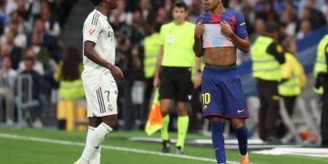 Vinicius Junior (kiri) berbicara dengan Lamine Yamal dalam pertandingan Liga Spanyol antara Real Madrid vs Barcelona di Stadion Santiago Bernabeu di Madrid pada 26 Oktober 2025. (Foto oleh Oscar DEL POZO / AFP)(AFP/OSCAR DEL POZO)