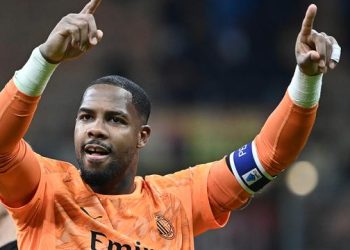 Kiper AC Milan, Mike Maignan, merayakan golnya di akhir pertandingan Serie A Italia antara AC Milan dan AS Roma di Stadion San Siro, Milan, pada 2 November 2025. (Isabella BONOTTO / AFP)