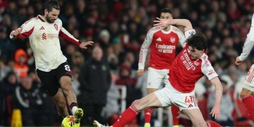 Pemain Liverpool, Dominik Szoboszlai (kiri), dan pemain Arsenal, Declan Rice, saling berebut bola dalam pertandingan Liga Inggris, Jumat (9/1/2026). (c) AP Photo/Ian Walton