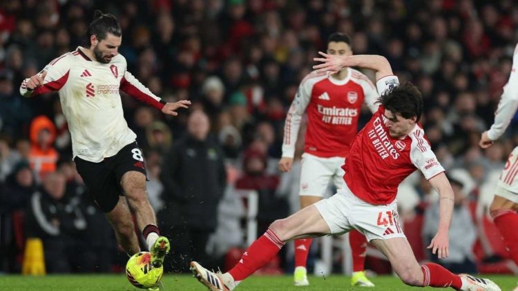 Pemain Liverpool, Dominik Szoboszlai (kiri), dan pemain Arsenal, Declan Rice, saling berebut bola dalam pertandingan Liga Inggris, Jumat (9/1/2026). (c) AP Photo/Ian Walton