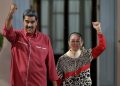 Presiden Venezuela Nicolas Maduro bersama istrinya, Cilia Flores, melambaikan tangan di luar Istana Kepresidenan Miraflores saat menghadiri aksi dukungan terhadap hasil pemilihan presiden di Caracas, 7 Agustus 2024. (Photo by Yuri CORTEZ / AFP)