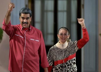 Presiden Venezuela Nicolas Maduro bersama istrinya, Cilia Flores, melambaikan tangan di luar Istana Kepresidenan Miraflores saat menghadiri aksi dukungan terhadap hasil pemilihan presiden di Caracas, 7 Agustus 2024. (Photo by Yuri CORTEZ / AFP)