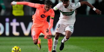 Pemain Barcelona Lamine Yamal (kiri) berebut bola dengan pemain Elche John Donald pada laga La Liga/Liga Spanyol antara Elche vs Barcelona (c) AP Photo/Jose Breton