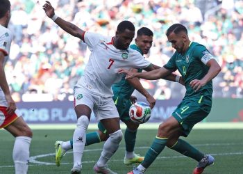 Penyerang timnas Suriname Gyrano Kerk dan bek Bolivia Luis Haquin berebut bola pada laga semifinal play-off kualifikasi Piala Dunia FIFA 2026 antara Bolivia dan Suriname di Stadion BBVA di Guadalupe, Meksiko pada 26 Maret 2026.(AFP/JULIO CESAR AGUILAR)