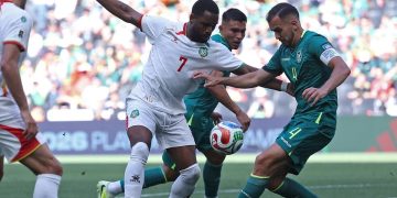 Penyerang timnas Suriname Gyrano Kerk dan bek Bolivia Luis Haquin berebut bola pada laga semifinal play-off kualifikasi Piala Dunia FIFA 2026 antara Bolivia dan Suriname di Stadion BBVA di Guadalupe, Meksiko pada 26 Maret 2026.(AFP/JULIO CESAR AGUILAR)