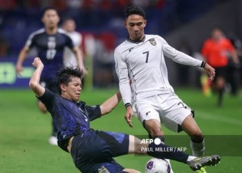 Kota Takai mencegah aksi Marselino Ferdinan dalam duel timnas Jepang vs Indonesia di Osaka (10/6/2025). (PAUL MILLER/AFP)